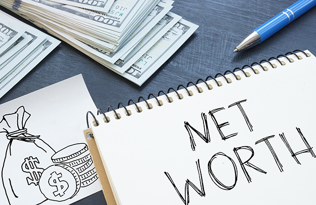 Net Worth written on a notebook next to a stack of cash and pen